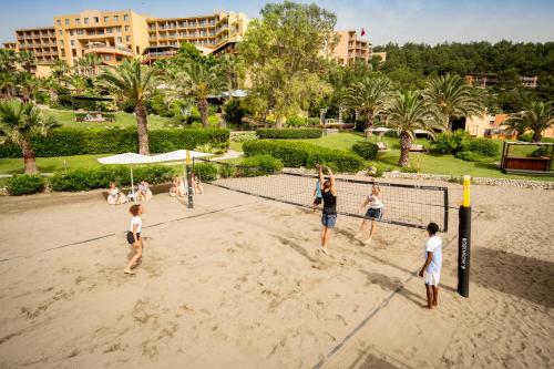 a group of children playing volleyball on the beach at ROBINSON SARIGERME PARK - All Inclusive in Dalaman