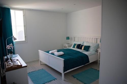 Un dormitorio con una cama con sábanas verdes y una ventana en Antalóczy Winery&Apartments, en Tokaj
