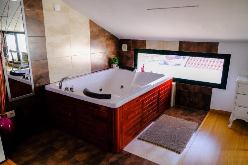 a large tub in a bathroom with a large screen at Atico Romántico in El Barraco