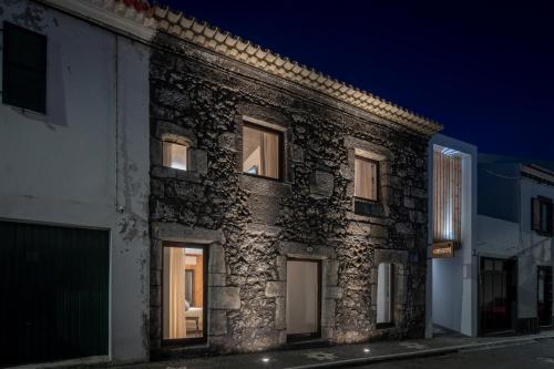 an old stone building with windows at night at North Shore Hostel in Ribeira Grande