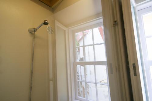 a bathroom with a shower and a window at Change The World Hostels - Coimbra - Almedina in Coimbra
