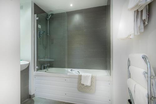 a bathroom with a shower and a tub and a sink at Queens Hotel & Spa in Brighton & Hove