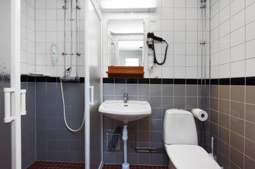 a bathroom with a sink and a toilet and a shower at Ersta Hotell & Konferens in Stockholm