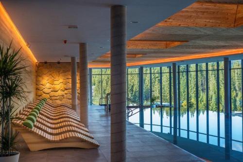 a room with a bed and a wall of glass at Hotel SOREA SNP in Demanovska Dolina