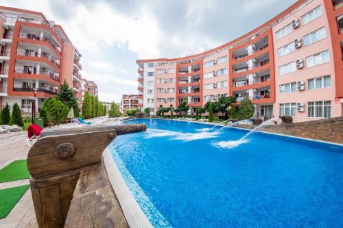 a swimming pool with a fountain in front of some buildings at Privillege Fort Noks Beach Apartments in Elenite