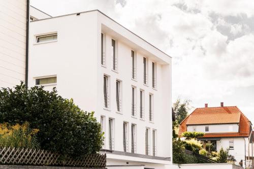 un edificio blanco al lado de una casa en Brenzapartments Königsbronn 1 und 2, en Königsbronn