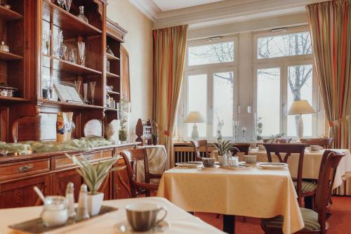 ein Esszimmer mit 2 Tischen und einem großen Fenster in der Unterkunft Hotel Klute in Osnabrück