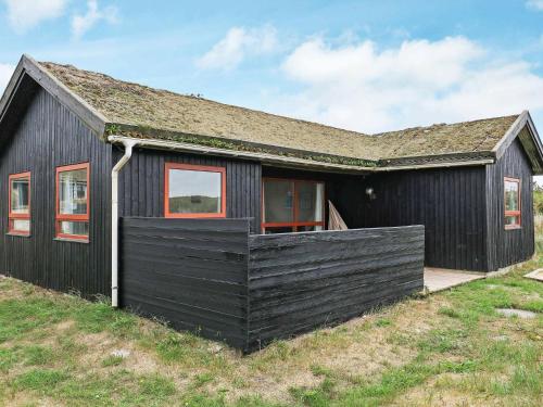 ein schwarzes Haus mit einem Gameradach in der Unterkunft 6 person holiday home in Henne in Henne Strand