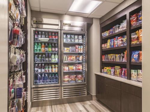 a store aisle with a refrigerator filled with drinks at Wingate by Wyndham Brunswick GA I-95 in Brunswick