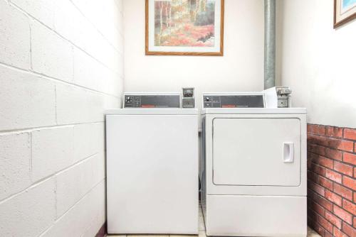 a white refrigerator sitting next to a brick wall at Days Inn by Wyndham Grove City Columbus South in Grove City