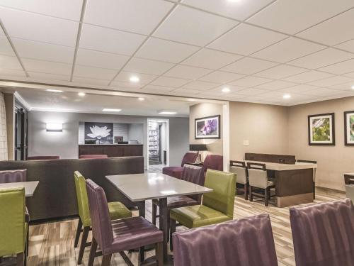 a waiting room with tables and chairs in a restaurant at Wingate by Wyndham Brunswick GA I-95 in Brunswick