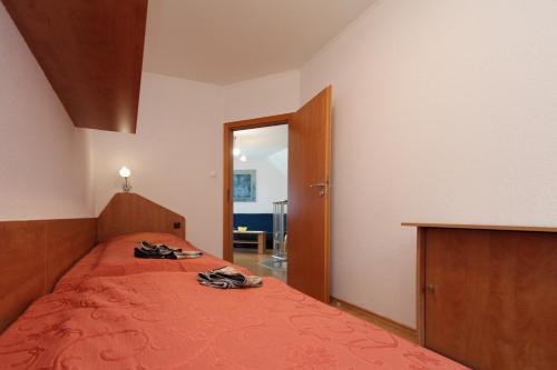 a bedroom with a bed with orange sheets and a mirror at Apartamenty Solar in Wisła