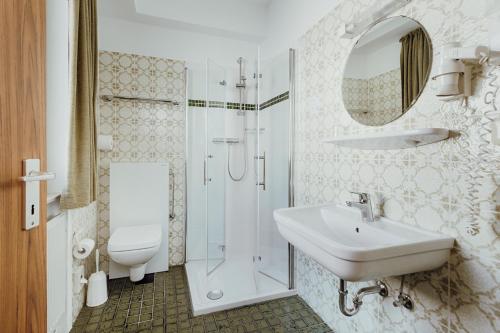 ein Bad mit einem Waschbecken, einer Dusche und einem WC in der Unterkunft Hotel Klute in Osnabrück