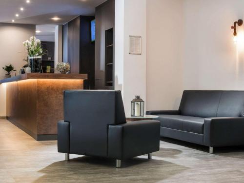a waiting room with two chairs and a couch at ibis Styles Hotel Gelsenkirchen in Gelsenkirchen
