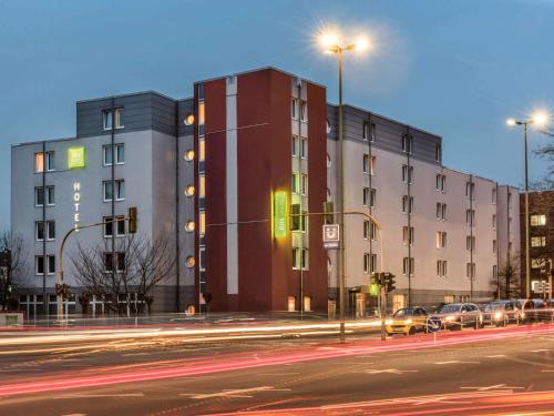a building on a street with cars parked in front of it at ibis Styles Hotel Gelsenkirchen in Gelsenkirchen