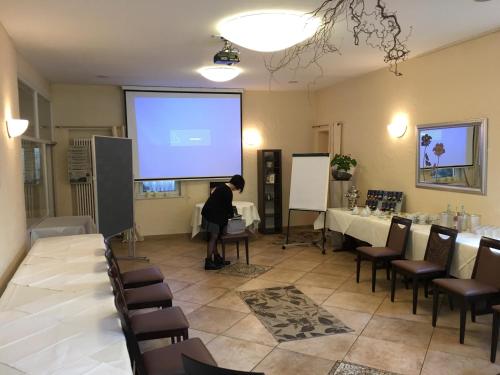 a person standing in front of a screen in a room at Hotel Ebnet in Mutterstadt