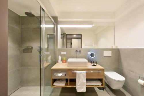 een badkamer met een wastafel, een toilet en een douche bij K-Apart Hotel & Boardinghouse in Hürth
