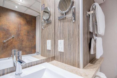 a bathroom with a sink and a mirror at Clarion Cedar Court Wakefield Hotel in Wakefield