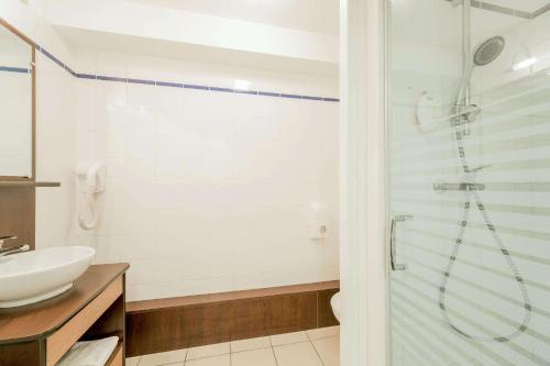 a bathroom with a shower and a sink at Comfort Suites Pau Idron in Idron