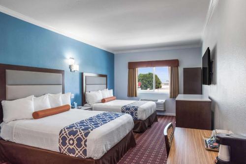una camera d'albergo con due letti e una finestra di Rodeway Inn & Suites - Pasadena a Pasadena