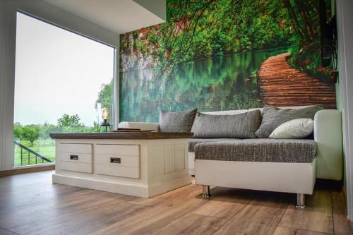 a living room with a couch and a large painting at Bungalovi Ključ in Ključ