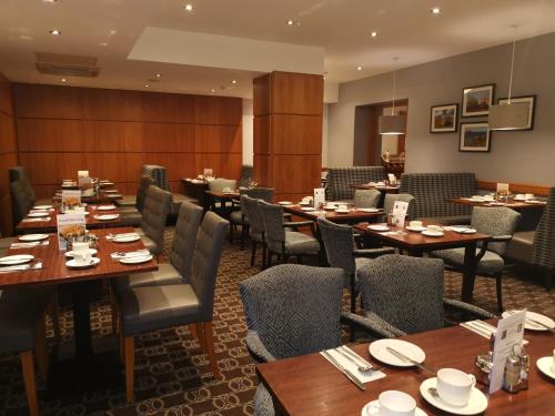 a dining room with wooden tables and chairs at Best Western Kings Manor in Edinburgh