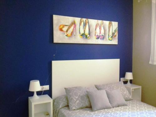 a bedroom with a bed with a painting of shoes on the wall at Apartamentos Bergantes in Ortells