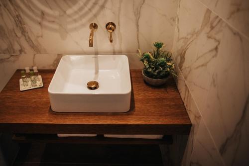 a white sink on a wooden counter in a bathroom at 1930 Boutique Hotel in Arzúa