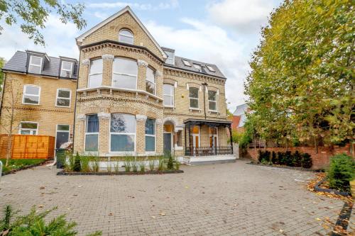 a large brick house with a large driveway at Modern and light 2 bed flat in SW2 in London