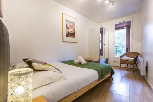 une chambre avec un lit, une table et une fenêtre dans l'établissement Apartment with terrace Gentianes 1 Centre Chamonix by Aiguille du Midi, à Chamonix-Mont-Blanc