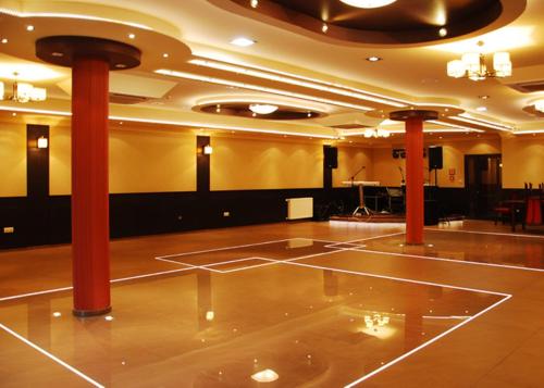 a large room with red columns and a dance floor at Hotel Texicana in Sulechów