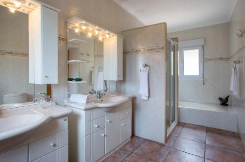 a bathroom with two sinks and a shower and a tub at El Hayuco 10 in Jávea