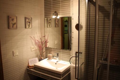 un baño con lavabo y espejo en Las casitas de La Velilla, en Pedraza-Segovia