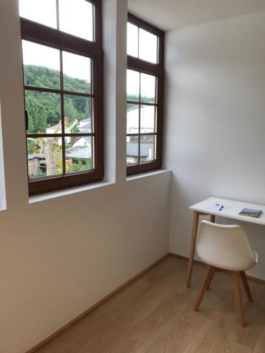 a room with a table and two windows at A Casa da Botica in Samos