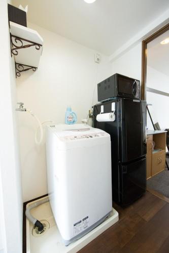 a kitchen with a refrigerator and a microwave at Cozyhouse 310 free wifi a rented electric bicycle in Kyoto