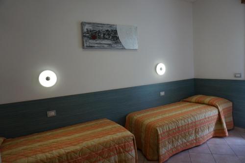 a room with two beds and lights on the wall at Villaggio Mare Blu in Bibione