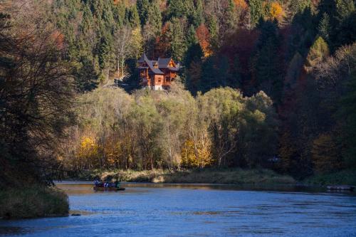 a house sitting on the side of a river at Schronisko PTTK Orlica in Szczawnica