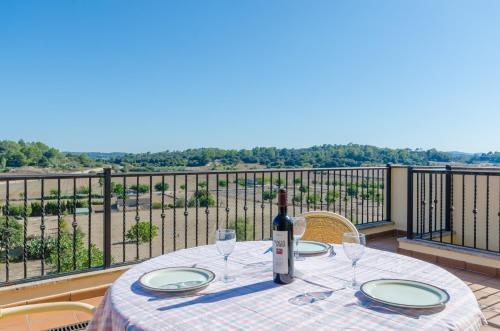 a table with a bottle of wine and glasses on a balcony at CAN NADAL - ADULTS ONLY in Sineu