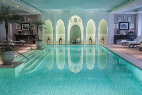 a large swimming pool in a building with a swimming pool at Palazzo Parigi Hotel & Grand Spa - LHW in Milan