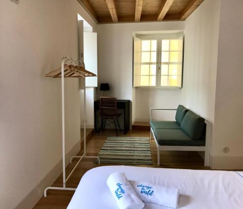 1 dormitorio con 1 cama, 1 silla y 1 ventana en Change The World Hostels - Coimbra - Almedina, en Coímbra