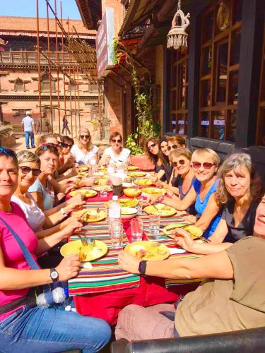 a group of people sitting around a long table at Shiva Guest House in Bhaktapur