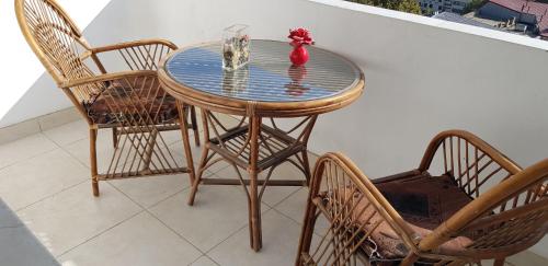 a glass table with chairs and a vase on a balcony at Baku Sea View Hotel in Baku