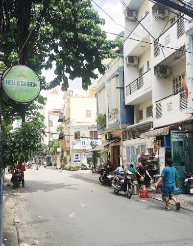 a man is walking down a city street with a sign at Hello SaiGon Homestay in Ho Chi Minh City