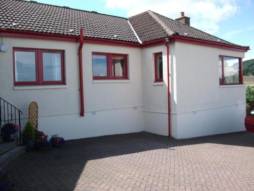 a white house with red windows and a driveway at Osnaburgh B&B in Cupar