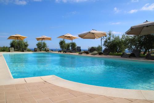 a large swimming pool with umbrellas on top of it at Agriturismo Vulcano in Mirto Crosia