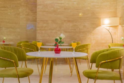 a dining room with tables and green chairs at Hyatt Buyutat Serviced Apartments in Riyadh