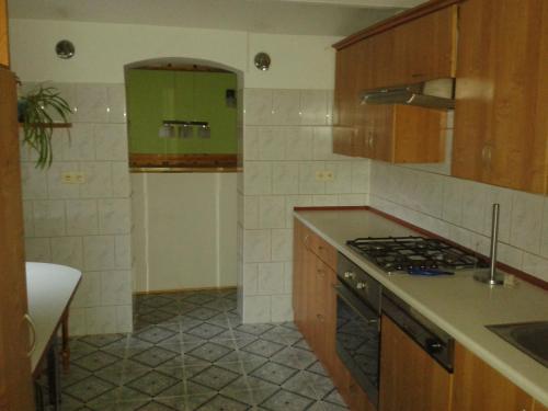 a kitchen with wooden cabinets and a stove top oven at Spacious Holiday Home in Stara Kamienica with Pond in Stara Kamienica