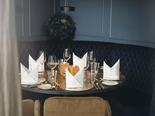 a table with white paper napkins and wine glasses at Boutiquehotel Blaue Burg Falkenstein in Pfronten