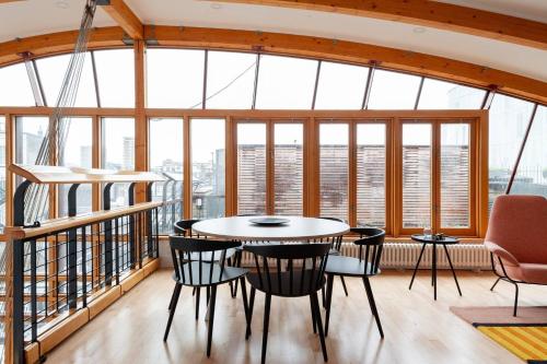 a table and chairs in a room with windows at Hausd - Piccadilly Circus in London
