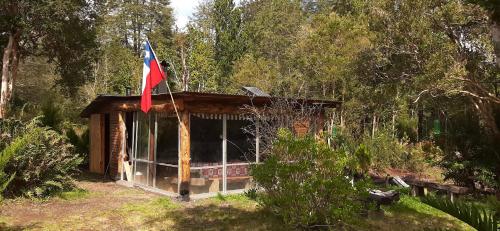 a small cabin with a flag on top of it at Cabañas Los Volcanes Ensenada Puerto Varas in Ensenada